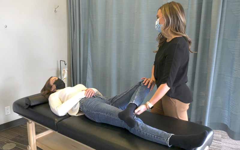 physiotherapist helping patient with chronic hip pain